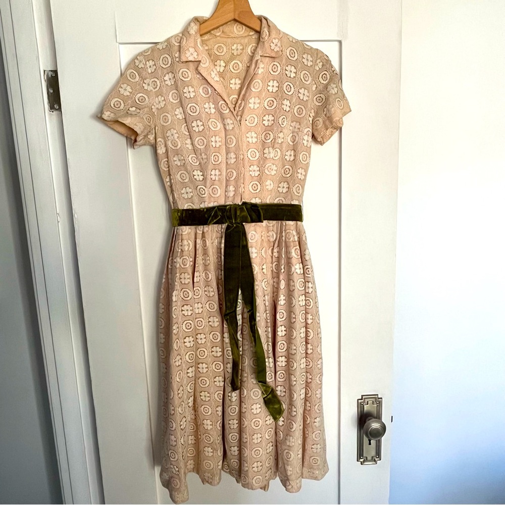 1960s vintage lace dress with attached velvet green belt at the waist.